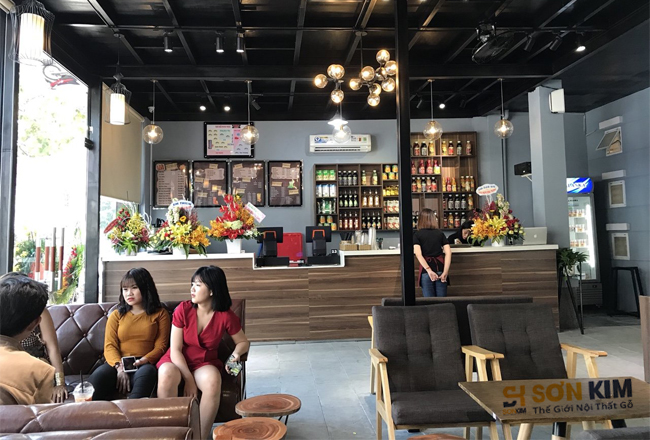 bàn ghế gỗ nệm ở 1 góc quán phù hợp cho gia đình, bạn bè